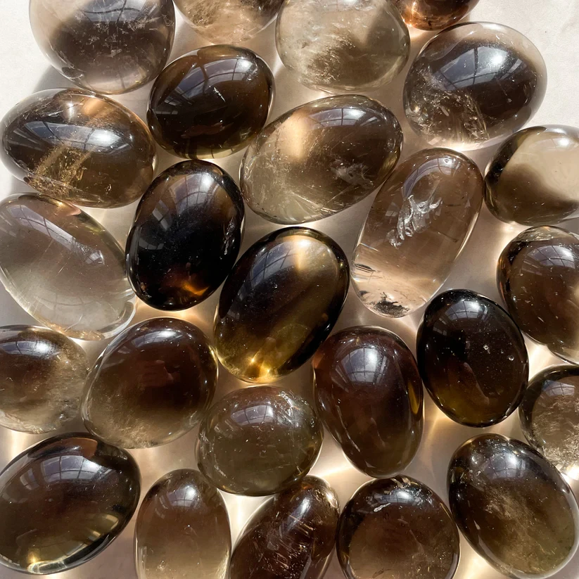 Polished smoky quartz stones used as grounding crystals for Earth Element energy balance.