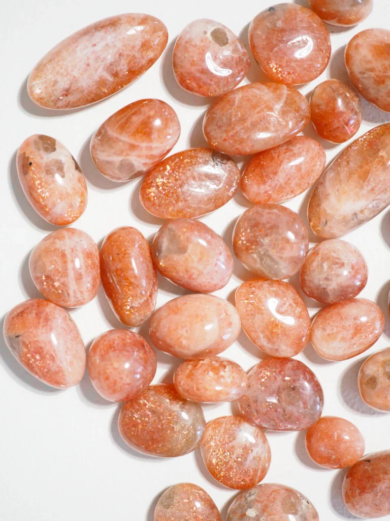Polished sunstone crystals displaying natural orange tones and shimmering inclusions