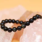 black obsidian bracelet natural stone beads on crystal background