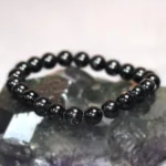 black tourmaline bracelet natural black crystal beads on stone background