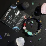 Cancer birthstone bracelet displayed on a constellation card listing traits like intuitive and loyal.