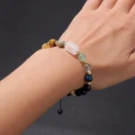 Close-up of a gemini birthstone bracelet featuring bright Citrine and Tiger's Eye beads on a wrist.