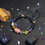 Sagittarius birthstone bracelet resting near raw turquoise and lapis lazuli stones on a dark surface.