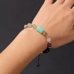 Close-up of a pisces birthstone bracelet featuring sea-blue Aquamarine and purple Amethyst beads on a wrist.