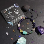 Scorpio birthstone bracelet displayed on a kraft paper card with traits like passionate and loyal.