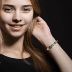 A young woman smiling while wearing a taurus crystal bracelet for daily energy balance.