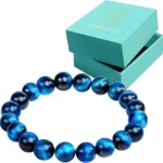 Blue glass bead bracelet placed in front of a turquoise Conscious jewelry box.