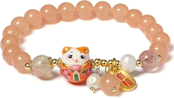 Peach-colored beaded bracelet with a decorative Maneki-Neko charm and gold accents.
