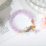 purple lucky charm bracelet styled on book aesthetic background