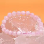 rose quartz bead bracelet pink stones on crystal background